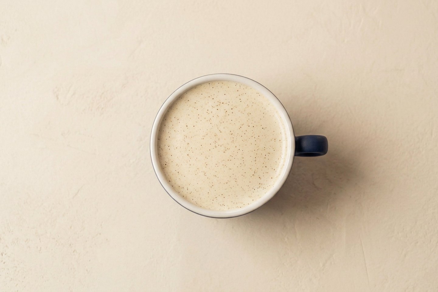 Raf coffee — espresso, cream and vanilla sugar — in a matte navy latte bowl on a marble counter at Krasivo Beauty Cafe, Upper East Side