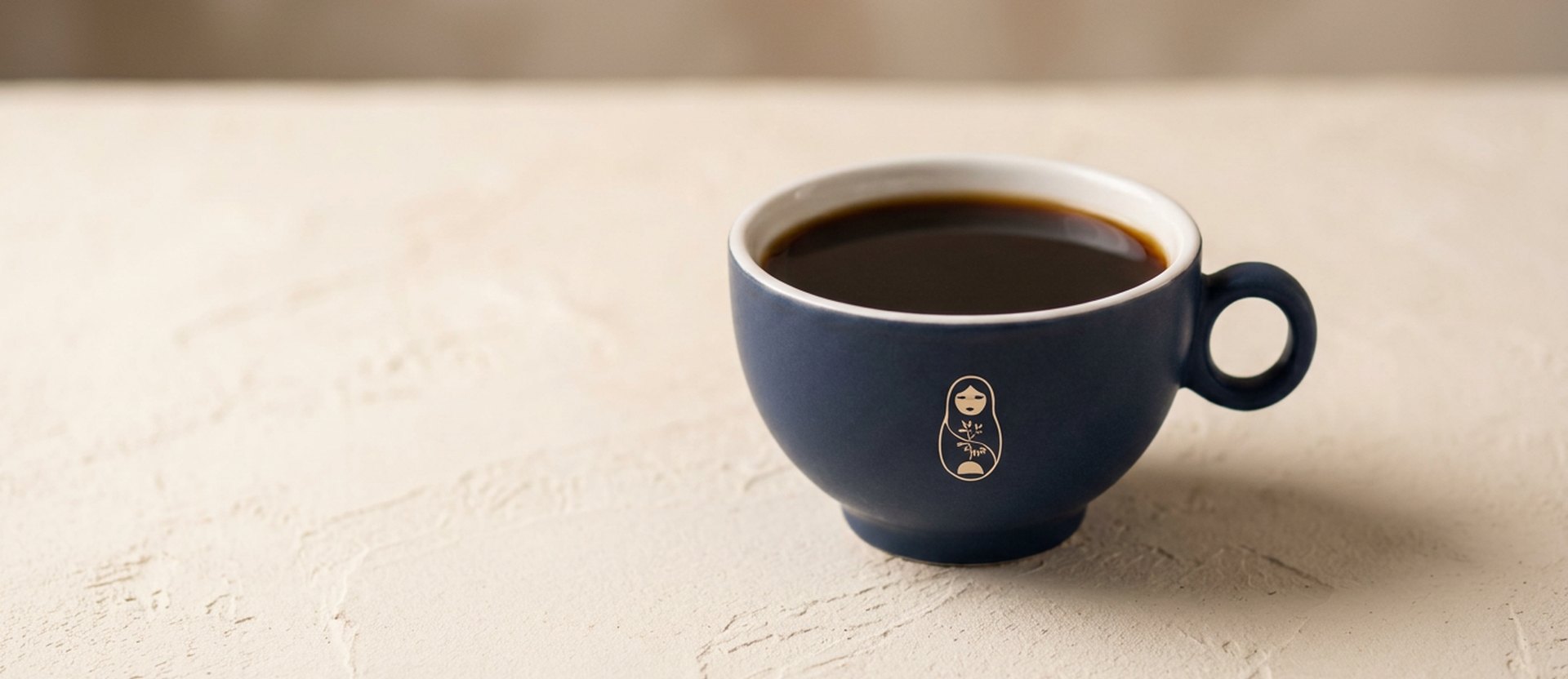 Espresso in a matte navy ceramic cup on a plain surface at Krasivo Beauty Cafe, Upper East Side New York